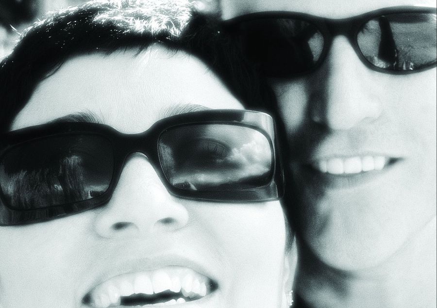 Leticia and Ron Rippy, cheek to cheek in sunglasses, laughing.